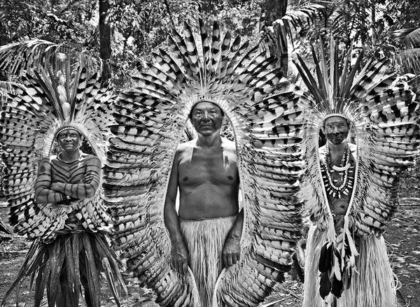 Three Yawanawá men wearing traditional outfits.