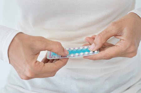 Woman with birth control pills and white sweater