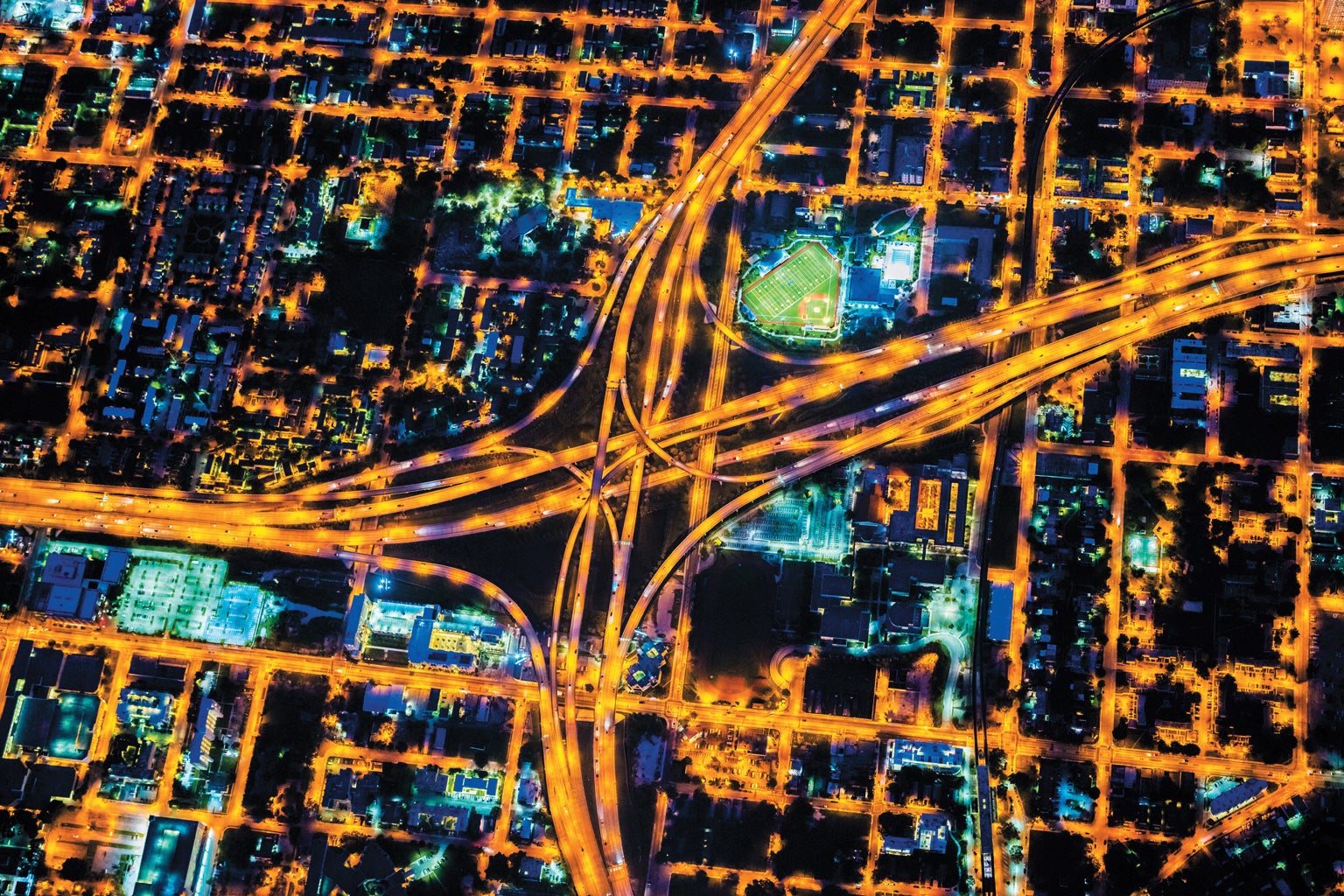 Aerial view of Miami streets and freeway lights at night.
