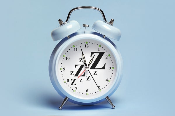 A blue alarm clock with Z's scattered around clockface, sitting on a blue background/surface