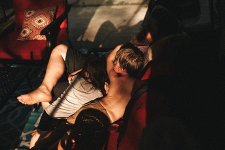 kids lay on their father on a hot summer day