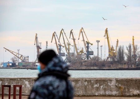 A soldier is seen in the foreground of the Mariupol Port.