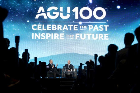 Michael Bloomberg speaks with Jerry Brown on stage at a conference.