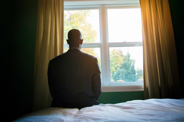 Man in suit sitting alone in front of window