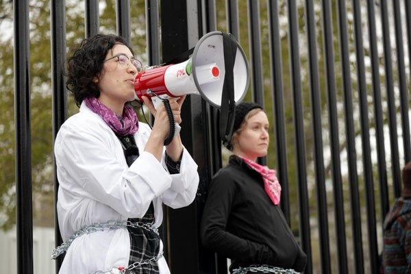 Activist scientist chained to a fence with a megaphone