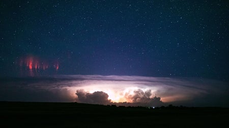 Moody storm clouds with small spiky red clouds in upper left hand corner