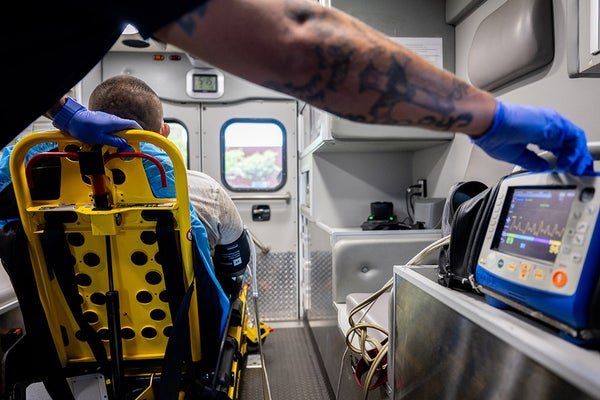 An EMT tends to a patient in an ambulance