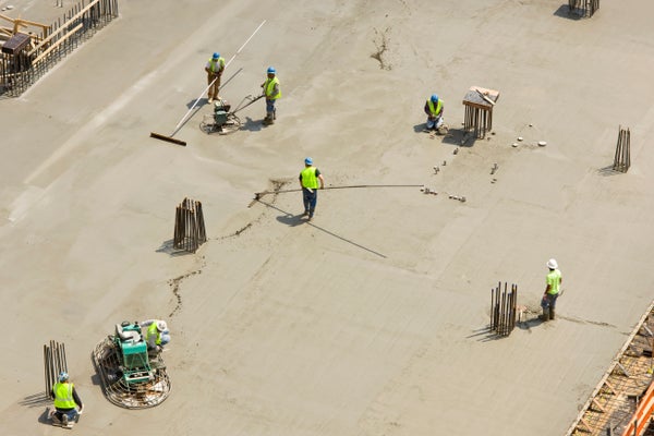 Construction Workers Preparing Concrete Floor Slab