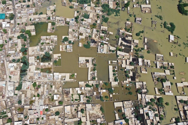 Aerial photograph homes surrounded by floodwaters.