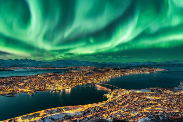 Aurora Borealis dancing over Tromso, Norway's urban Skyline