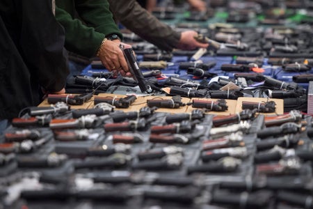 Table displaying dozens of handguns for sale