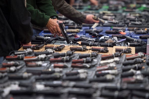 Table displaying dozens of handguns for sale