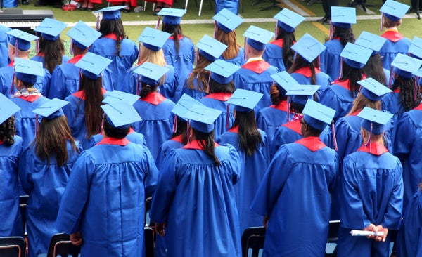 Graduates standing after receiving their diplomas