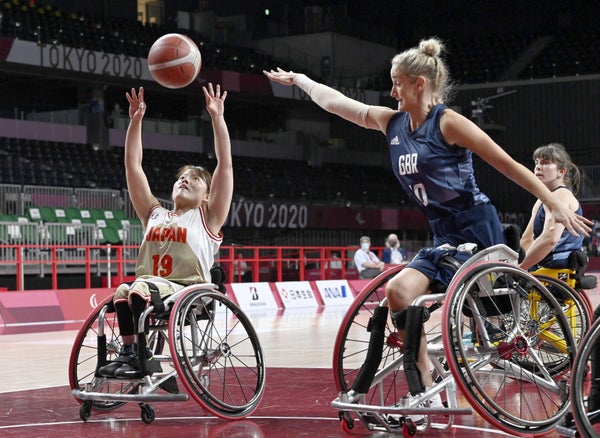 Two athletes compete in a women's wheelchair basketball game.