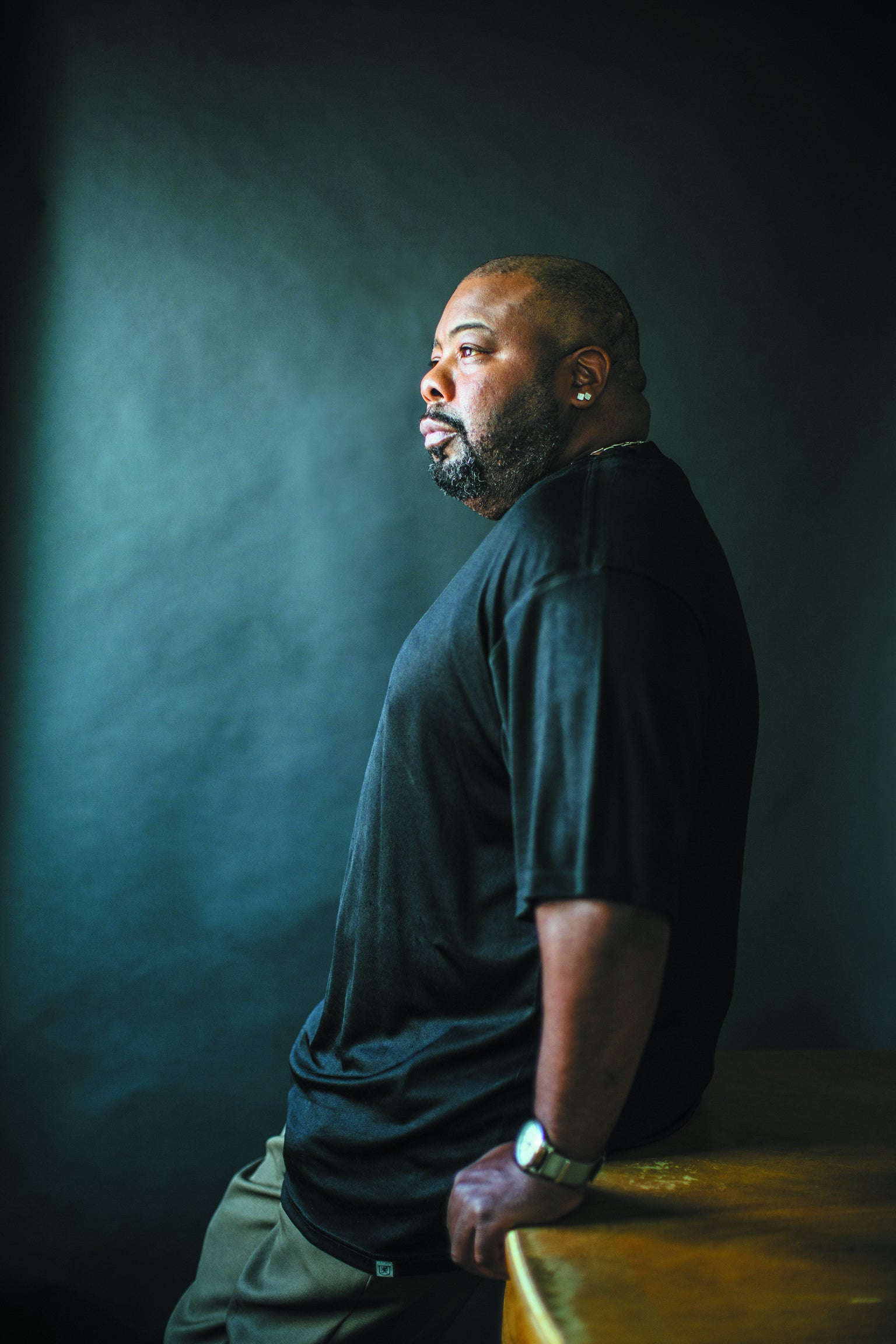 Torrence Irvin stands against a desk while staring ahead.