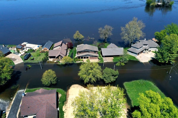 Aerial view, floodwater from the Mississippi River surrounds homes, trees and covers streets
