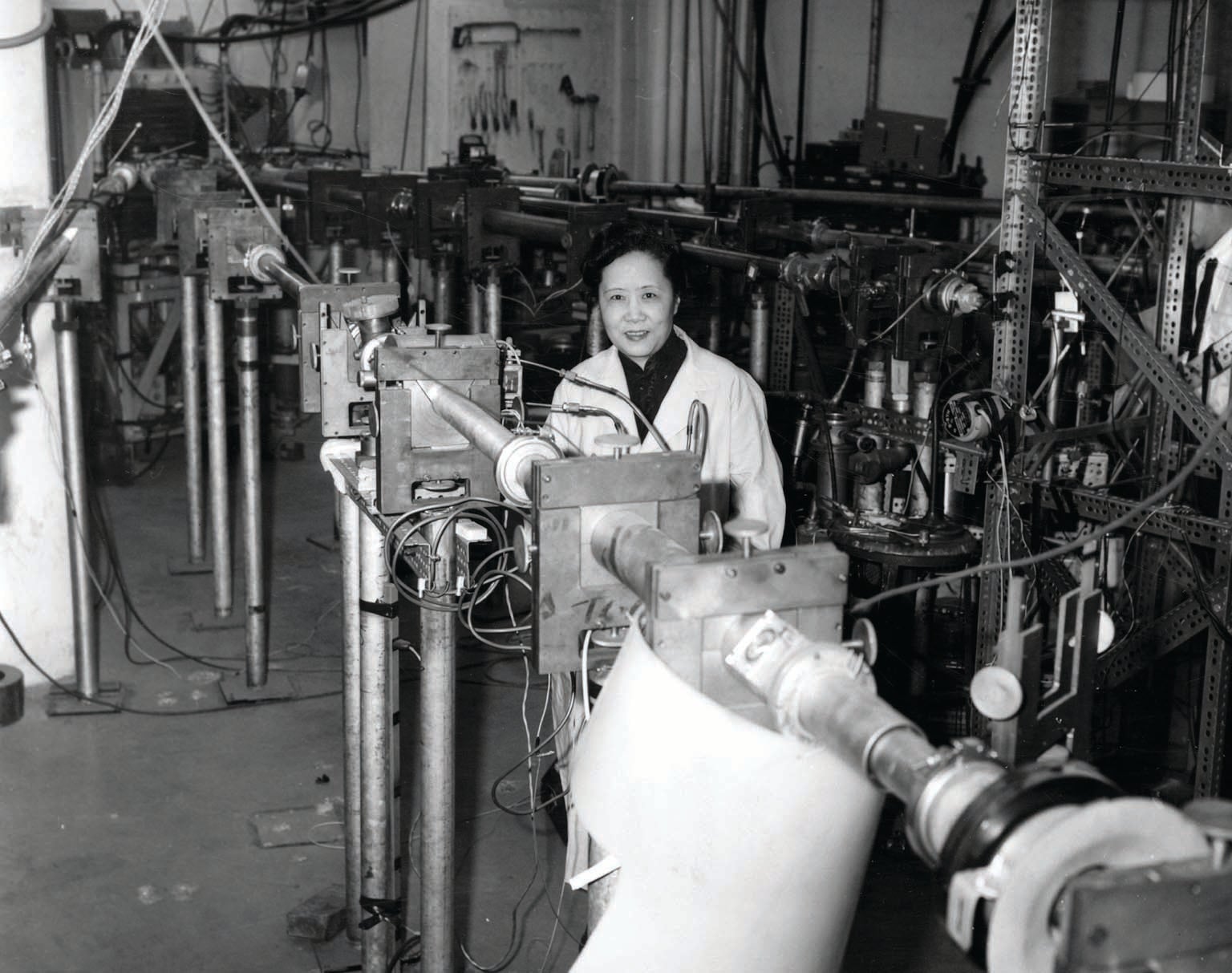 Chien-Shiung Wu shown in room with industrial scientific equipment.