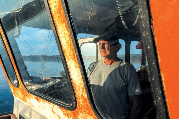 Man inside fishing boat on a sunny day.