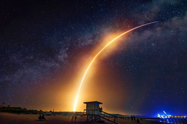 Arc of rocket launching into dark sky