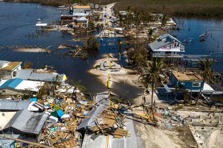 A broken section of the Pine Island Road and destroyed houses