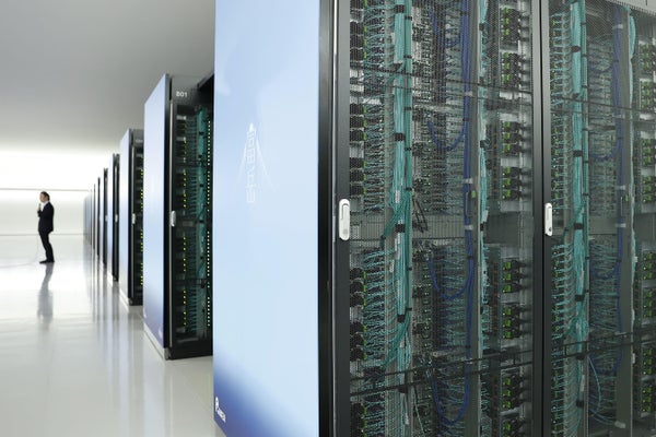 Row of Japan's new supercomputer Fugaku with a person standing to the left.