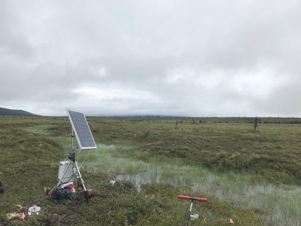 Scientific equipment in field under grey skies.