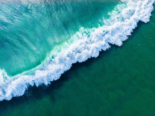 Overhead aerial shot of a wavy green sea