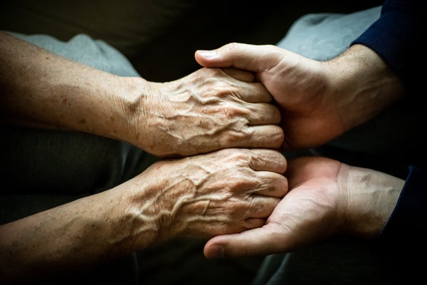 Close up of son holding his mother's hands