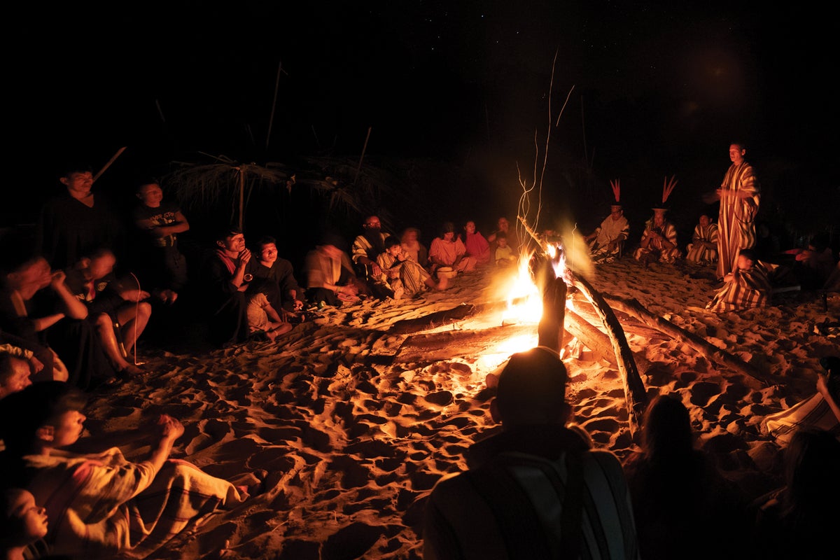 Community gathers around fireplace near the Amonia River.