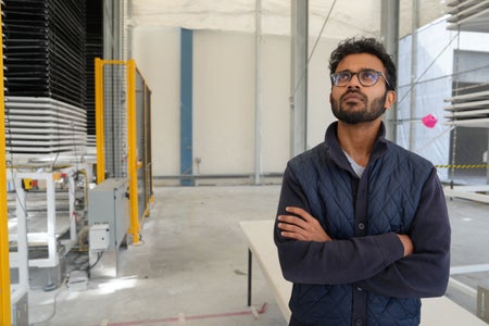 Shashank Samala looking up wearing glasses with crossed arms at the Heirloom Carbon headquarters.