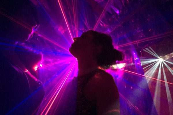 Woman dancing in front of purple lights.