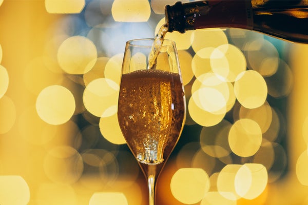 A glass of champagne on a festive bokeh background.