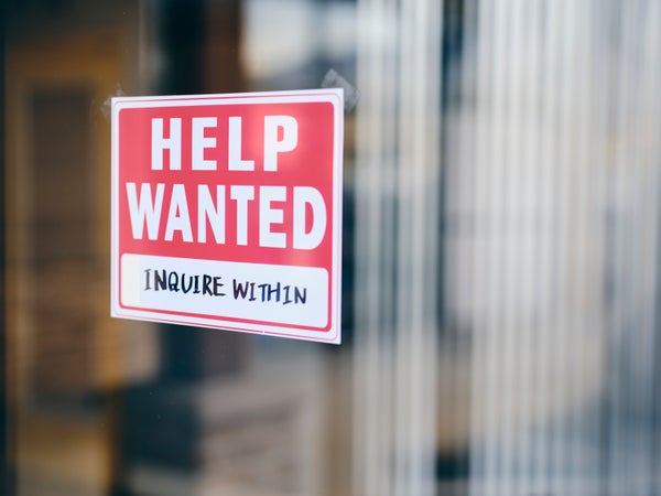 A small business help wanted sign in a window