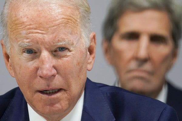 Close up of Joe Biden with John Kerry in background.