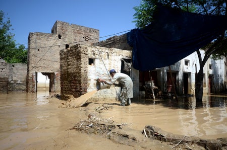 A man is seen with a bucket at a flooded area in Pakistan