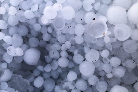 Many large hailstones piled on the ground, view from above