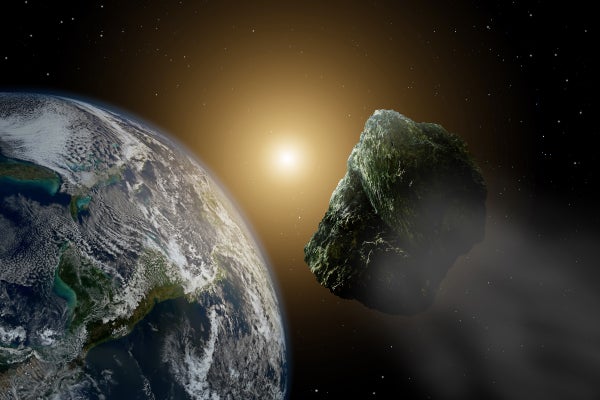 Asteroid in space near earth in sunlight