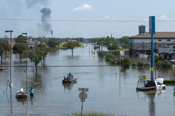 People in boats on a flooded highway