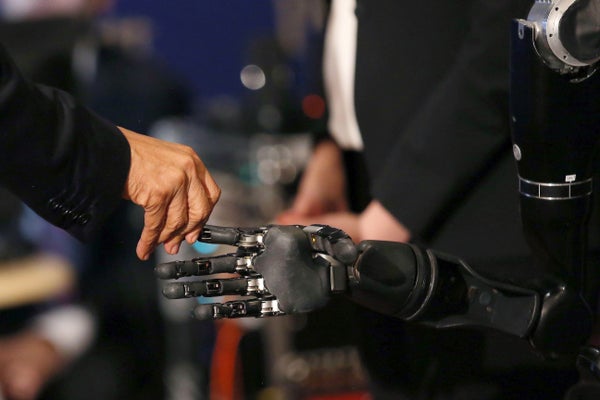 Barack Obama touches a robotic finger