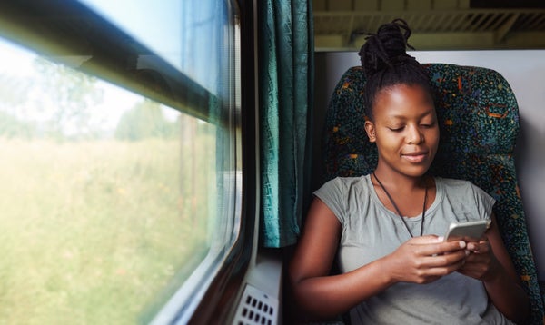A woman on a train checks her smartphone.