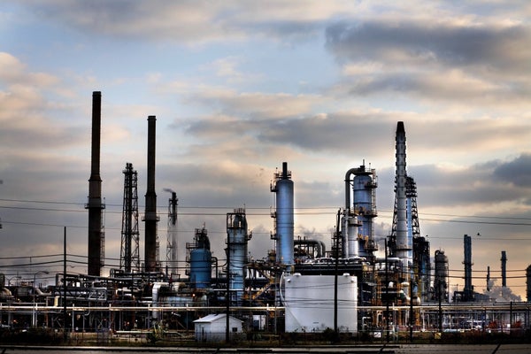 Gas refinery with chimneys and clouds in background