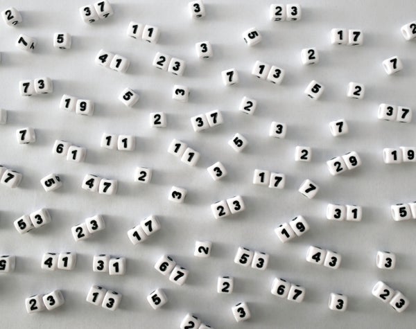Prime numbered white dice on white surface.