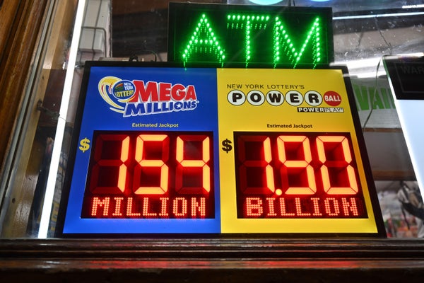 Advertisement in the window of a grocery store announces a Powerball jackpot of $1.9 billion dollars, and Mega Millions jackpot of $154 million