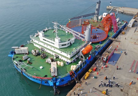 A cable laying ship being readied for departure at a construction base in Yantai.