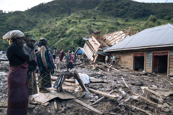Three women stand amidst rubble after landslide in the emocratic Republic of Congo.