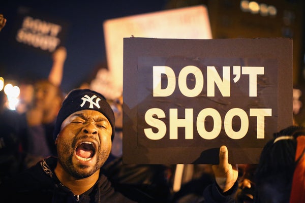 black male protester holding sign that reads "Dont' Shoot"
