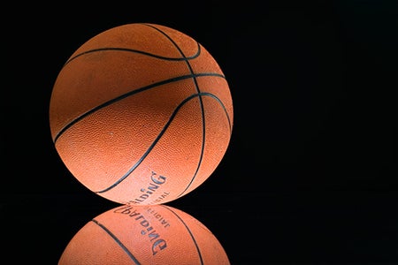 image of a basketball on a reflective surface with black background