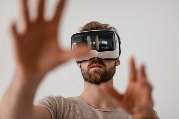 A man wearing a virtual reality headset with his hands outstretched in front of him.