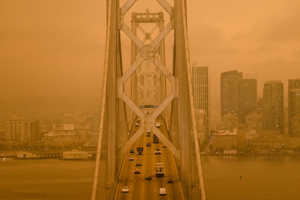 Polluted orange air surrounds a suspension bridge.