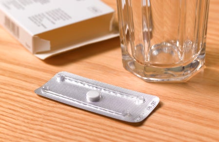 Morning after pill and glass on table